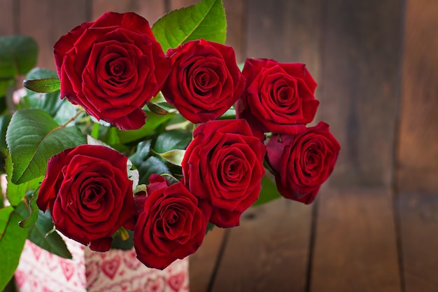 Bouquet of red roses on a wooden table.