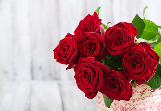 Bouquet of red roses on a wooden table.