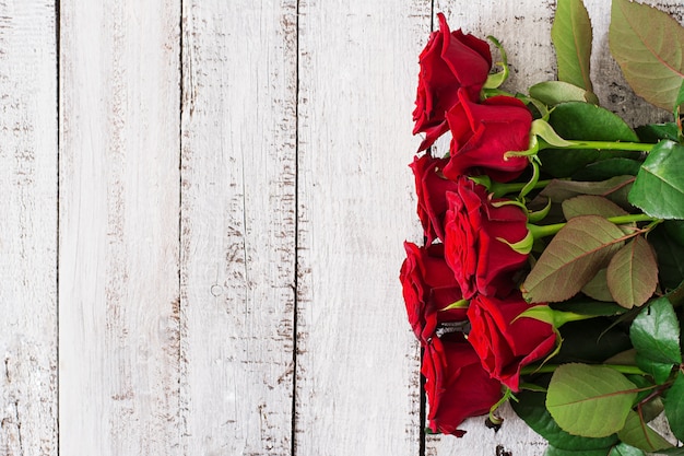 Photo bouquet of red roses on a wooden table.