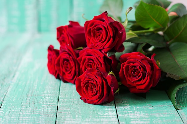 Bouquet of red roses on a wooden table.