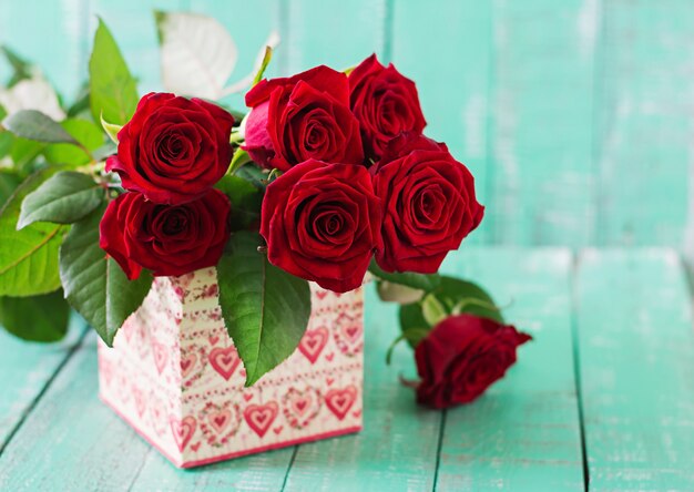 Bouquet of red roses on a wooden table.