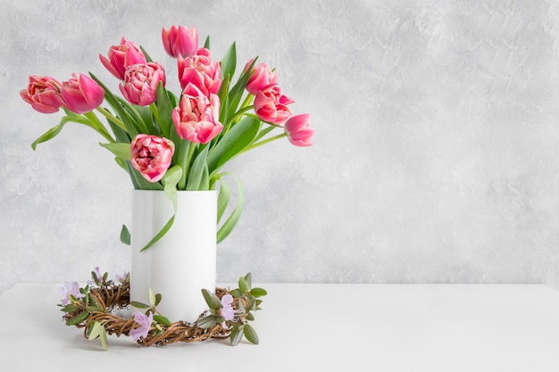 Bouquet of red tulip in vase on white vintage table