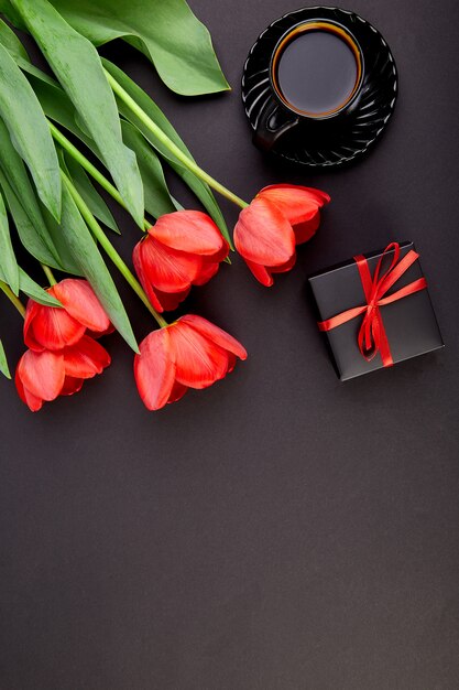 Bouquet red tulips and cup of coffee