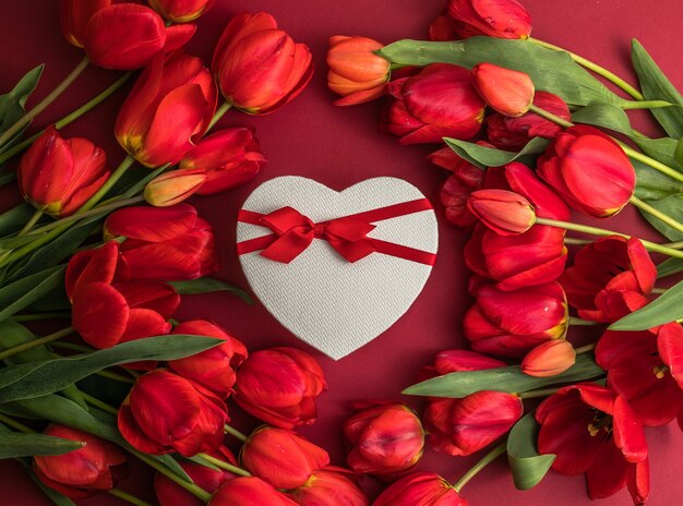 Bouquet of red  tulips and gift heart box, arrangement with a lot of copy space for text