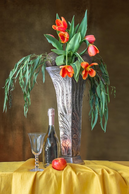 Photo a bouquet of red tulips in a tall art deco-style vase on a table with a yellow tablecloth.