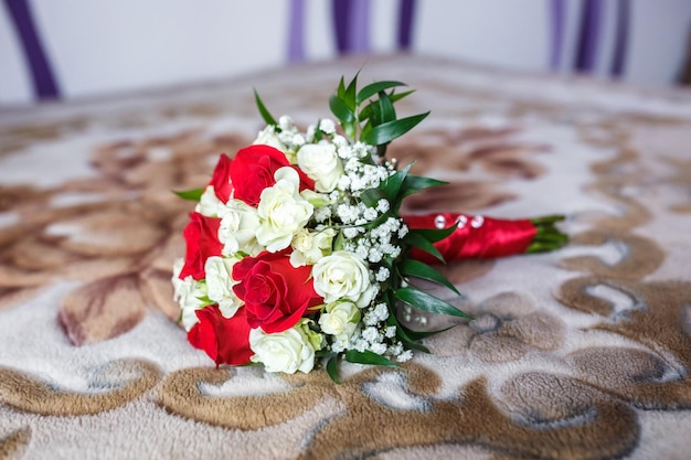 Bouquet of red and white roses with wedding rings