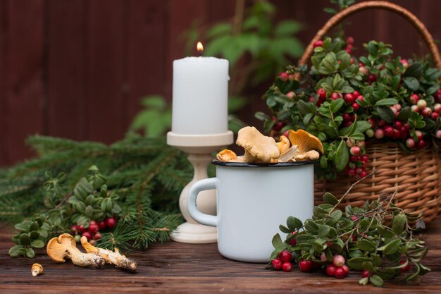 A bouquet of ripe red cranberries in a wicker basket Forest orange chanterelle mushrooms