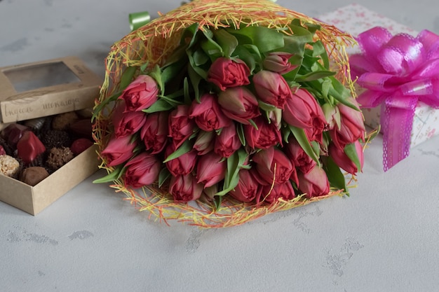 Bouquet of roses, box of chocolates and gift for Valentine