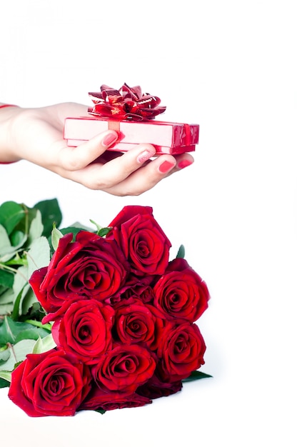 Bouquet of roses and hand with gift