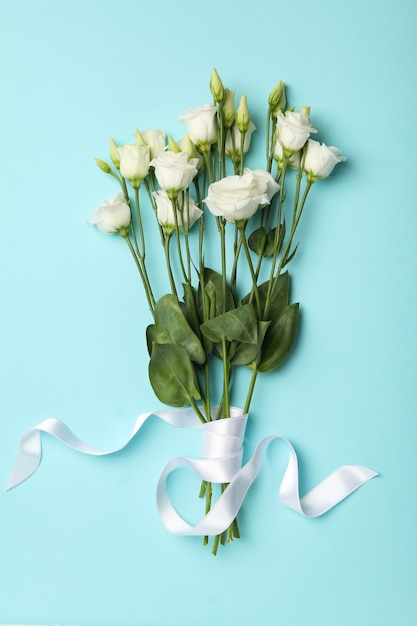 Bouquet of roses with ribbon on blue background