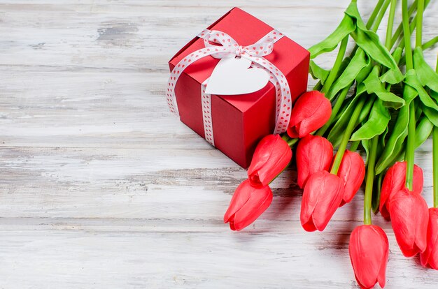 Bouquet of spring red tulips and gift