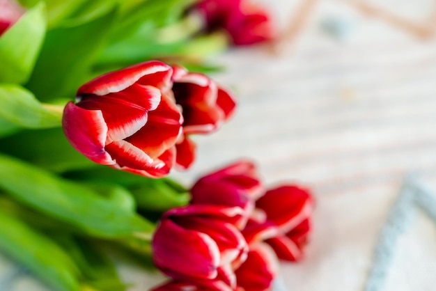 A bouquet of spring tulips on a white blanket on the bed