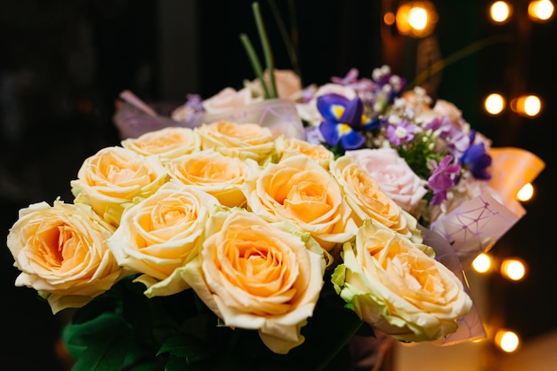 Foto bouquet di rose da tè fiori su uno sfondo scuro in un loft con luci calde