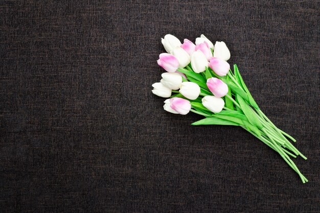 Bouquet of tulips on a dark textile