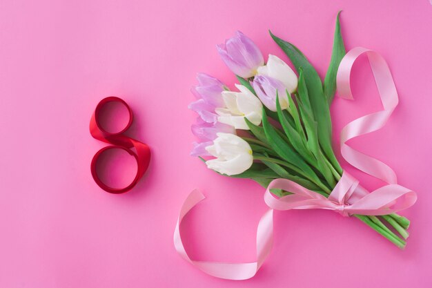 Bouquet of tulips on a pink pastel background.