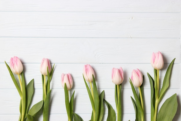 A bouquet of tulips on a wooden background top view spring background