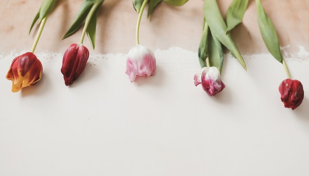 木製の素朴なテーブルの上のチューリップの花束。春の休日の概念の背景