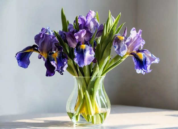 Bouquet van lente-irissen en tulpen in een doorzichtige vaas