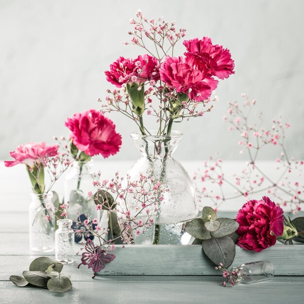 Bouquet van roze anjers op een lichte turquoise houten achtergrond