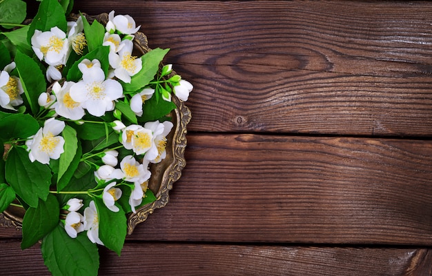 Bouquet of white blossoming jasmine on a copper plate