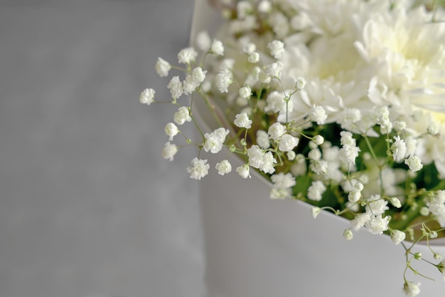 Bouquet of white chrysanthemums and gypsophila wrapped in craft paper delicate bouquet of white flowers Spring bouquet of white chrysanthemums closeup