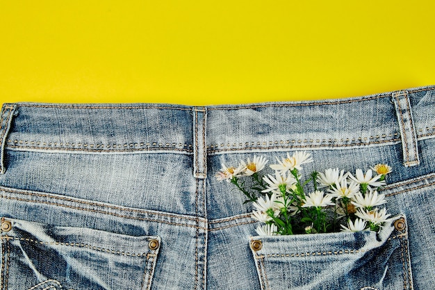 Foto bouquet di fiori bianchi nella tasca dei jeans