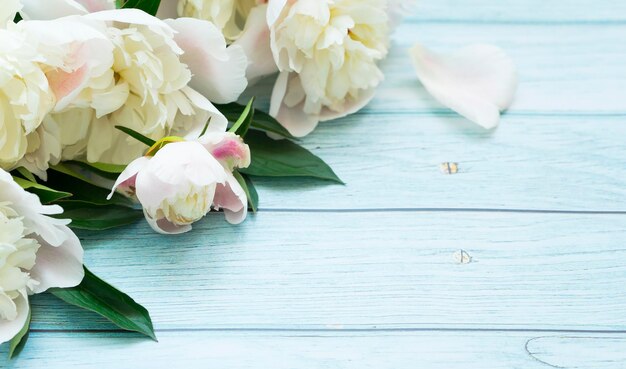 Bouquet of white peonies on a light blue wooden background Image with selective focus