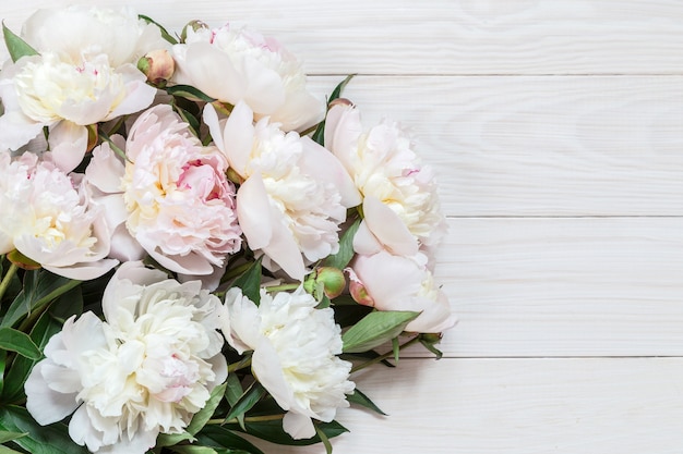 A bouquet of white peonies on a wooden background. Place for text.