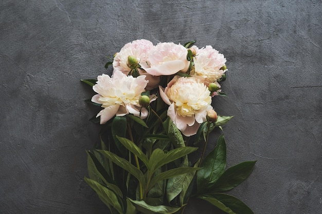 Bouquet white pink peonies flowers on a wooden background Flat lay minimalist aesthetic peonies Beautiful card for Mother's Day or Women's Day