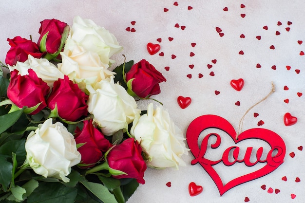 a bouquet of white and red roses and hearts of different sizes