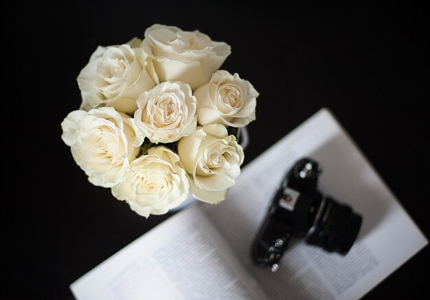 Bouquet of white roses on a black background, focus on flowers