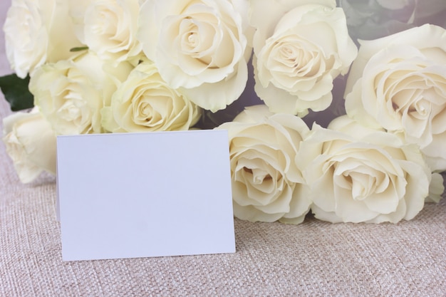 Bouquet of white roses and a blank card