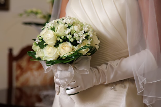 Foto mazzo di rose bianche nelle mani della sposa