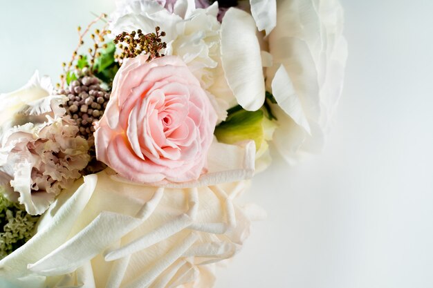 Bouquet of white roses lying on the white table closeup copy space