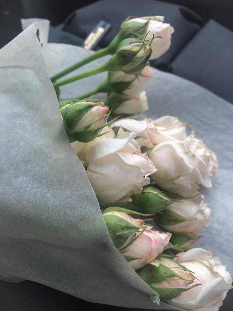 白いクラフト紙に白いバラの花束