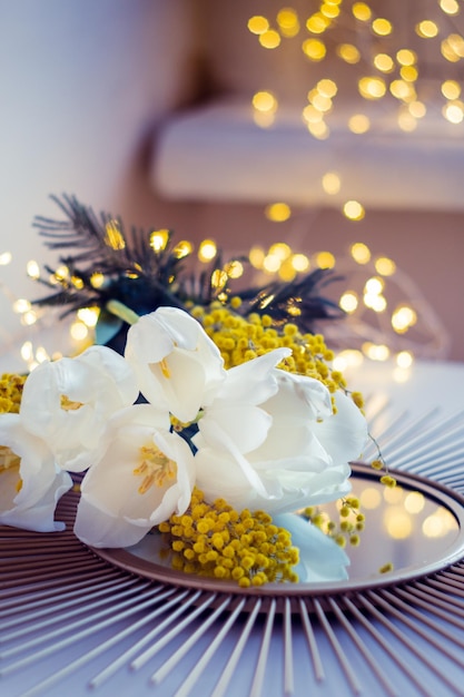 ミラー トレイに白いチューリップとミモザの花の花束