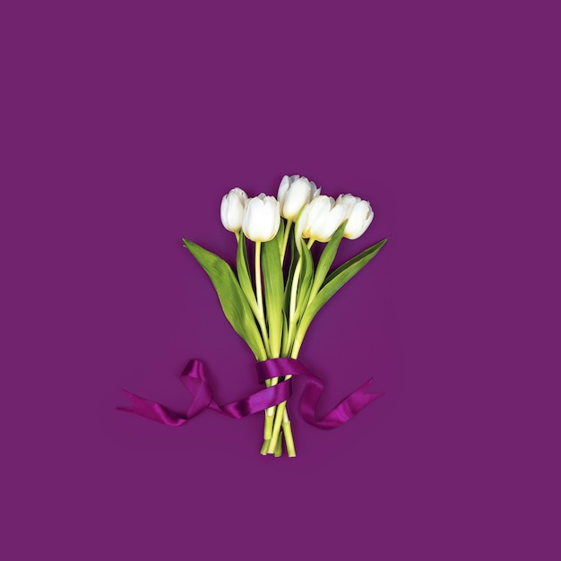 A bouquet of white tulips tied with a ribbon.