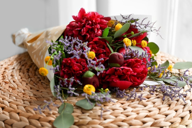 Bouquet with beautiful peonies on ottoman closeup