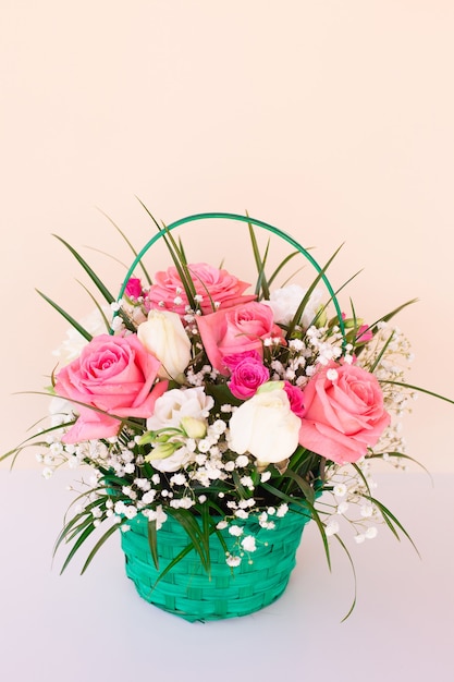 Bouquet with pink and white roses on light wall