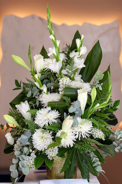 Bouquet of wonderful flowers from white chrysanthemums and lilies with the effect of blurring the sides Close up Still life with a bouquet of beautiful lilies in room on table Spring Flower