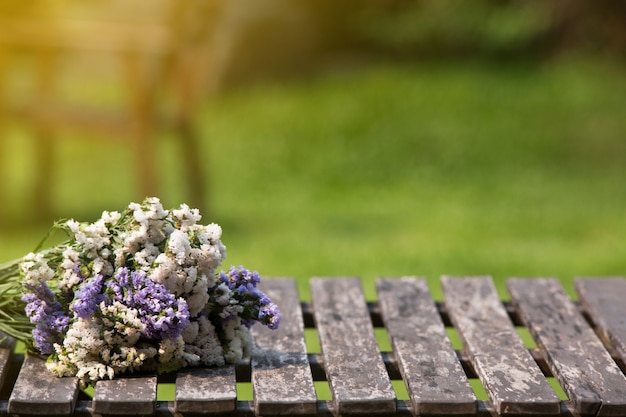 緑の芝生と木製のテーブルの上の花束