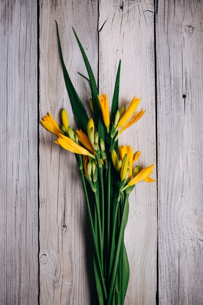 Photo bouquet of yellow lilies on a wooden background, wedding bouquet