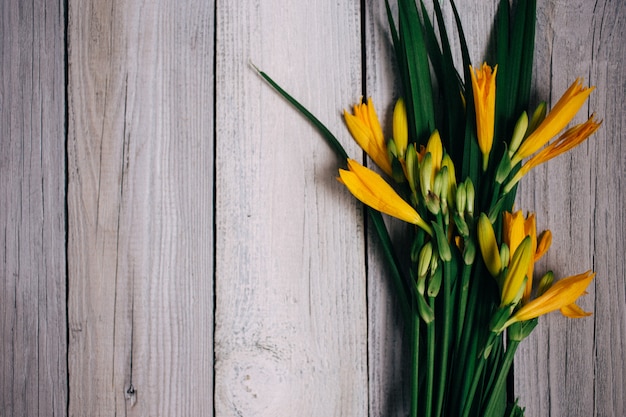 Photo bouquet of yellow lilies on a wooden background, wedding bouquet