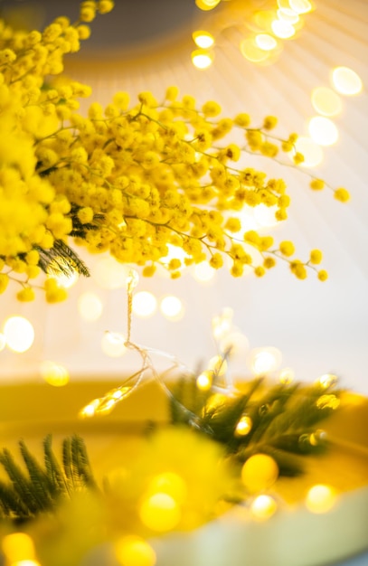 Foto bouquet di fiori di mimosa gialla con decorazioni interne in oro brillante con punti luce