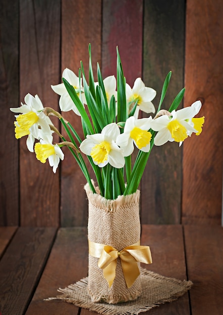 Bouquet of yellow narcissuses close up on a rustic wooden table