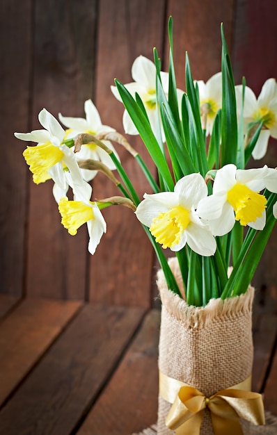 Bouquet of yellow narcissuses close up on a rustic wooden table