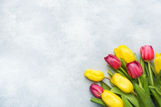 Bouquet of yellow and pink tulips on a light blue background. Copy space