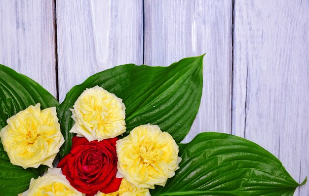 Bouquet of yellow and red roses with green leaves 