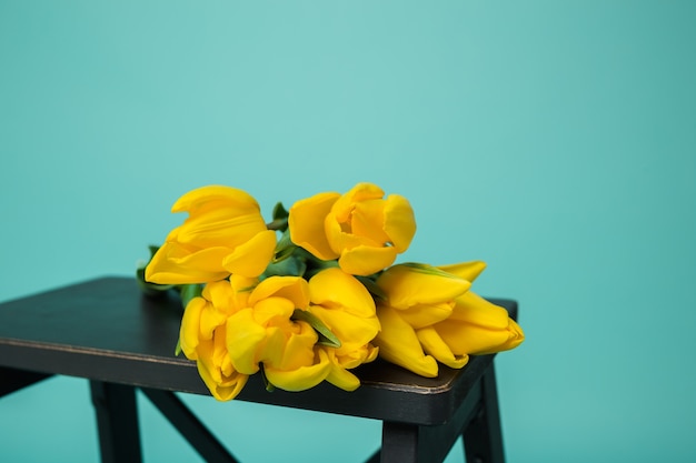 Bouquet of yellow tulips on turquoise