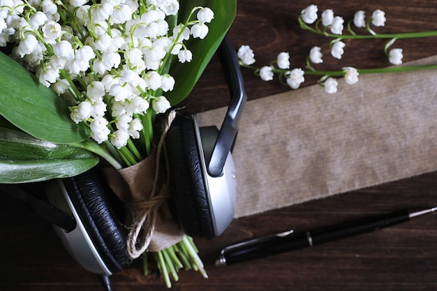 Bouquet of young lilies of the valley on a wooden table